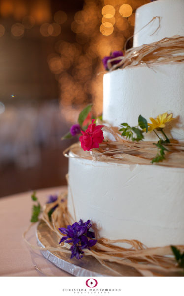 Round tiered wedding cake with wildflowers and twinkle lights at Armstrong Farms